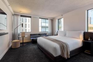 a hotel room with a bed and a chair at Lancemore Crossley St. Melbourne in Melbourne