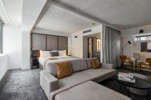 a hotel room with a bed and a couch at Lancemore Crossley St. Melbourne in Melbourne