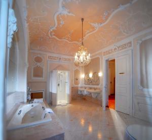 a large bathroom with a tub and a chandelier at Hotel Bristol Salzburg in Salzburg