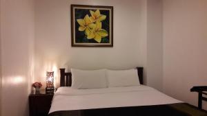 una camera da letto con un letto e un dipinto sul muro di Smile Society a Bangkok Altre 27 foto