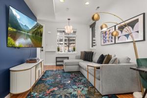 a living room with a couch and a tv at Rooftop Retreat with Workspace and BBQ in Denver
