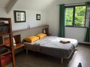 a bedroom with a bed with yellow pillows and a window at La ch'tite montagne in Cilaos