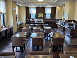 a dining room filled with tables and chairs at Hotel Route-Inn Dai-ni Suwa Inter in Suwa