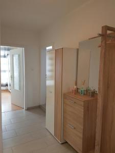 a kitchen with a refrigerator and a wooden cabinet at Apartment am Kaiserplatz in Düren - Eifel
