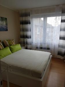Schlafzimmer mit einem weißen Bett und einem Fenster in der Unterkunft Apartment am Kaiserplatz in Düren - Eifel