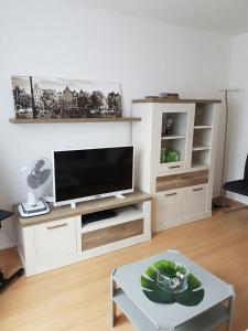 a living room with a tv and a coffee table at Apartment am Kaiserplatz in Düren - Eifel