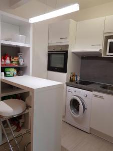 eine weiße Küche mit einer Waschmaschine und einer Theke in der Unterkunft Apartment am Kaiserplatz in Düren - Eifel