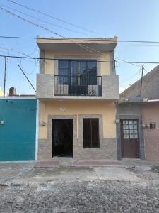 a house with a balcony on a street at Tequila Jalisco in Tequila
