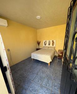 a bedroom with a bed and a yellow wall at Tequila Jalisco in Tequila