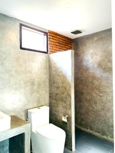 a bathroom with a white toilet and a window at GOODNIGHT Hill KOHYAOYAI in Ban Nai Wat