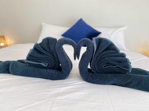 two towels shaped like swans on a bed at GOODNIGHT Hill KOHYAOYAI in Ban Nai Wat