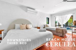 a bedroom with two beds and a beach house contender at Absolute Beachfront with Ocean Views 3 Beds plus Pool in Hideaway Bay