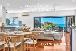 a living room with a couch and a table at Absolute Beachfront with Ocean Views 3 Beds plus Pool in Hideaway Bay
