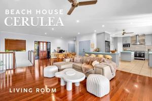 a living room with a couch and a table at Absolute Beachfront with Ocean Views 3 Beds plus Pool in Hideaway Bay +27 photos