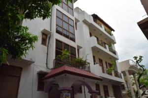 a building with a balcony with plants on it at Hotel Raj Palace in Rishīkesh