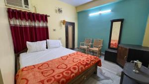 a bedroom with a bed and a table and chairs at Hotel Moon N' Net in Digha