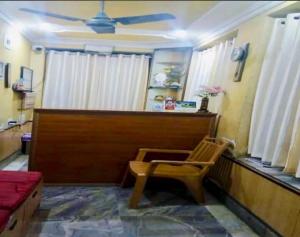 a living room with a ceiling fan and a chair at Hotel Moon N' Net in Digha