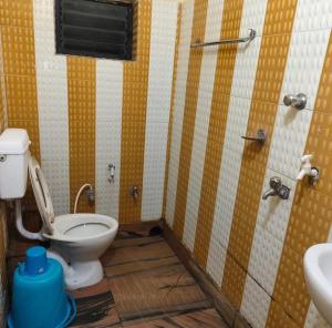 a bathroom with a toilet and a sink at Hotel Moon N' Net in Digha