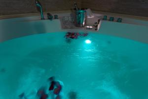 a bath tub filled with blue water next to a sink at Hotel Alexandros in Doxato
