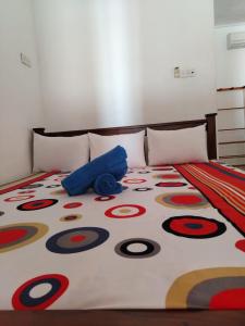 a bed with a colorful comforter on it at The Heritage Hotel in Polonnaruwa