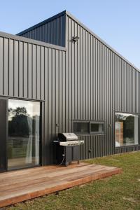 a black building with a grill on a wooden deck at The Dunes in Island Beach