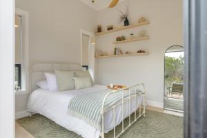 a bedroom with a bed with white sheets and a window at The Dunes in Island Beach