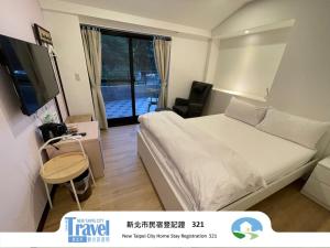 a hotel room with a bed and a television at Lucky House B&B in Jiufen