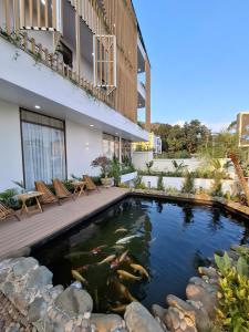 a koi pond in front of a building at Pataco Tam Coc Hotel in Vũ Lâm