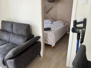 a mirror in a room with a couch and a bed at Studio climatisé SPA en option in Jacou