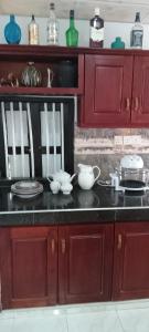 a kitchen with red cabinets and dishes on a counter at Villa Octopus in Maggona West