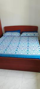 a bed with a red frame and a blue comforter at Villa Octopus in Maggona West
