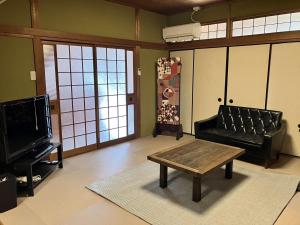 a living room with a couch and a coffee table at イマヅのかくれ家 in Fukuoka