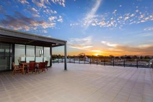 a patio with a table and chairs and a sunset at Mill 7 in Wagga Wagga