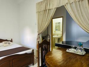 a bedroom with a bed and a table with a mirror at Kandyan Gate Homestay in Kandy