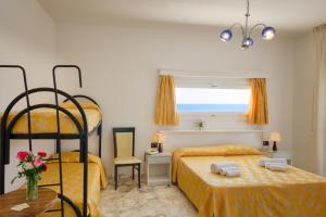 a bedroom with two beds and a window with the ocean at Hotel Luna Lido in Torre San Giovanni Ugento
