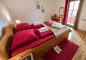 um quarto com uma grande cama de madeira com lençóis vermelhos em Apartments Mariborsko Pohorje em Hocko Pohorje