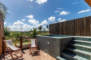 a patio with two chairs and a swimming pool at Aluá Patacho in Pôrto de Pedras