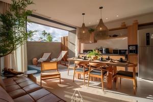 a kitchen and living room with a table and chairs at Aluá Patacho in Pôrto de Pedras