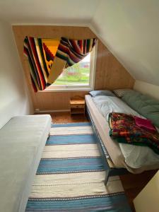 a small bedroom with a bed and a window at The Greenhouse in Eggum