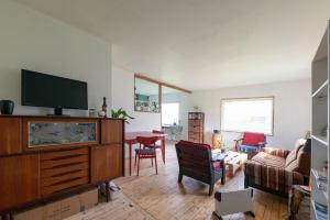 a living room with a flat screen tv on a dresser at The Greenhouse in Eggum