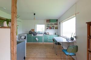 a kitchen with green cabinets and a table with chairs at The Greenhouse in Eggum