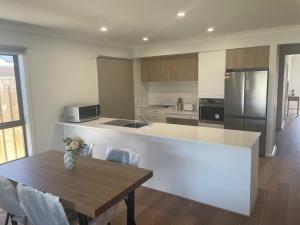 a kitchen with a wooden table and a counter top at Southern Retreat in Clyde North