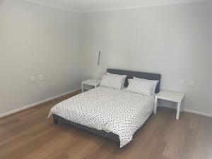 a bedroom with a bed and a side table at Southern Retreat in Clyde North