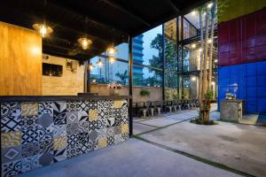 a room with a bar with tables and windows at Ccasa Hostel in Nha Trang