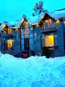 a house covered in snow in front at Cliffside cottage in Tangmarg
