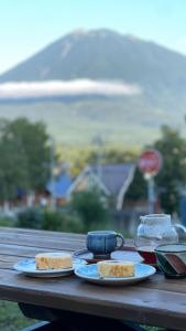 a wooden table with two plates of food on it at Log 343 by Elite Havens in Kutchan +32 photos