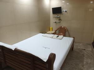 a hospital room with a bed and a tv at Hotel Mtc Guest House in Chennai