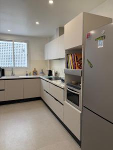 a kitchen with white cabinets and a refrigerator at Casaflor Tunis in Tunis