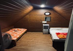 a room with two beds and a clock on the wall at The Wildcamp - Coorg in Kushālnagar
