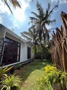 a house with a palm tree in a yard at Dasis villa in Hiriketiya